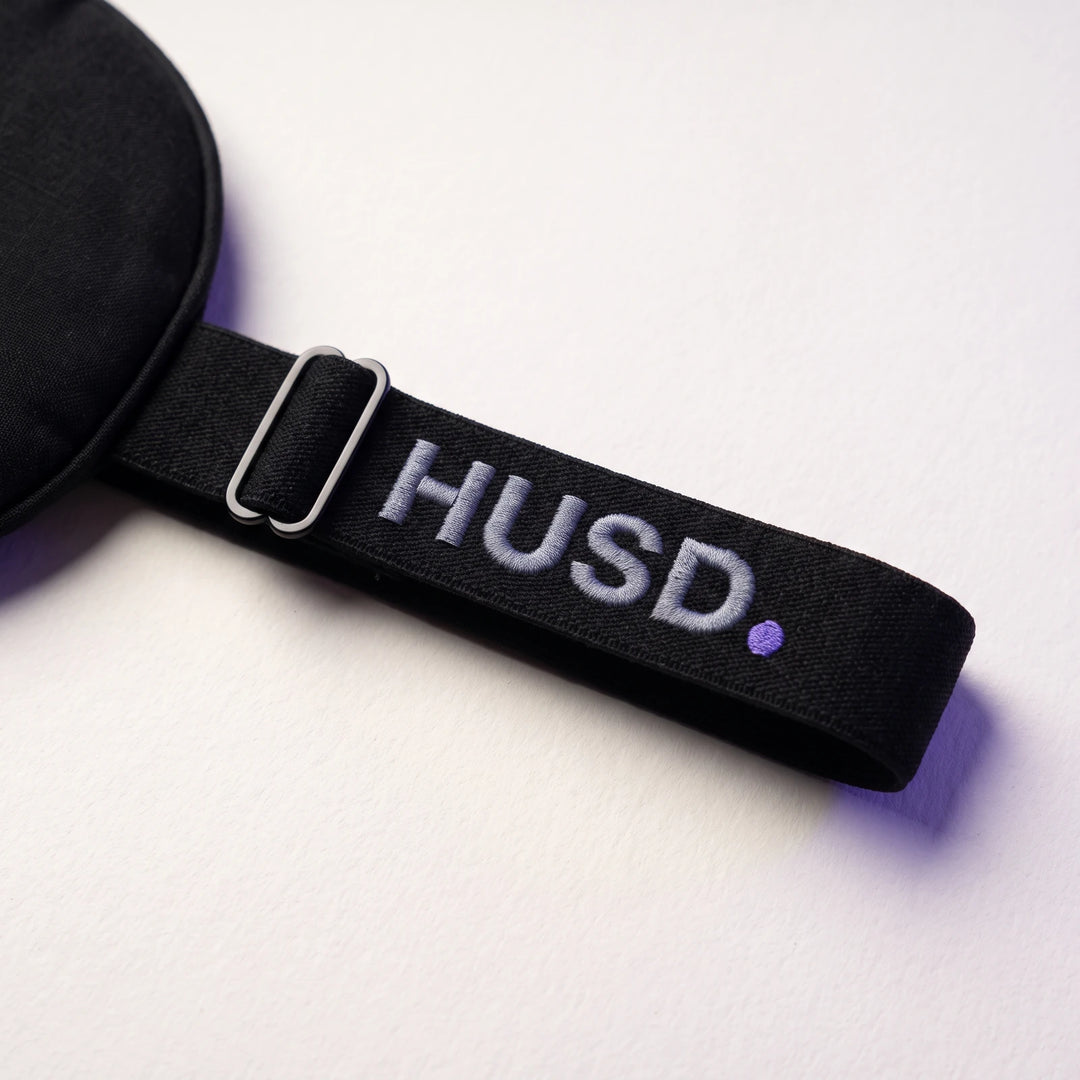 The flat woven strap with its low-profile slider and the embroidered HUSD mark