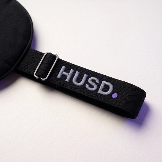 The flat woven strap with its low-profile slider and the embroidered HUSD mark
