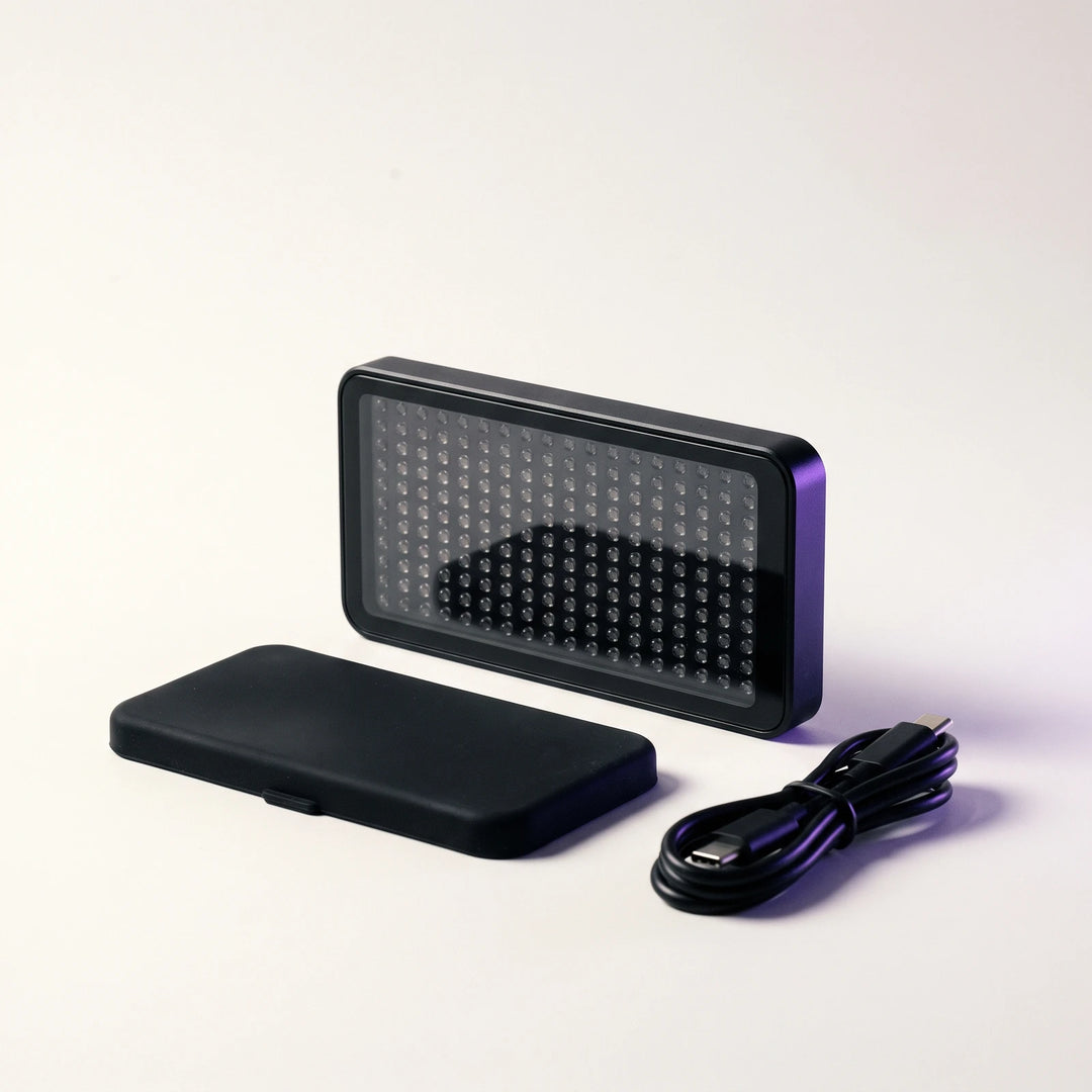 The Red and Infrared Light Panel standing beside its silicone cover and a USB-C cable