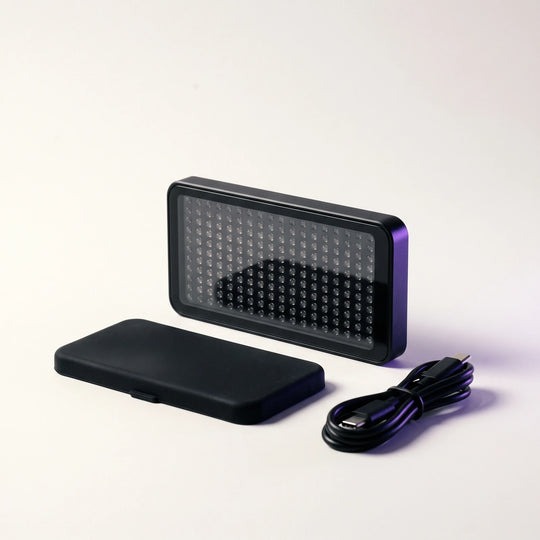 The Red and Infrared Light Panel standing beside its silicone cover and a USB-C cable