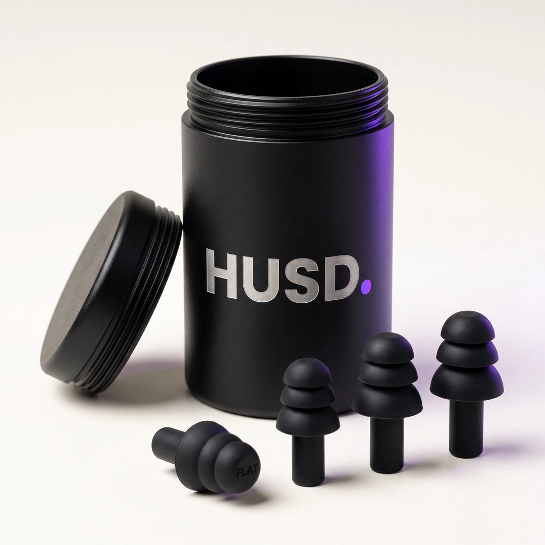 The aluminium HUSD case with its lid off and three pairs of silicone earplugs in front of it