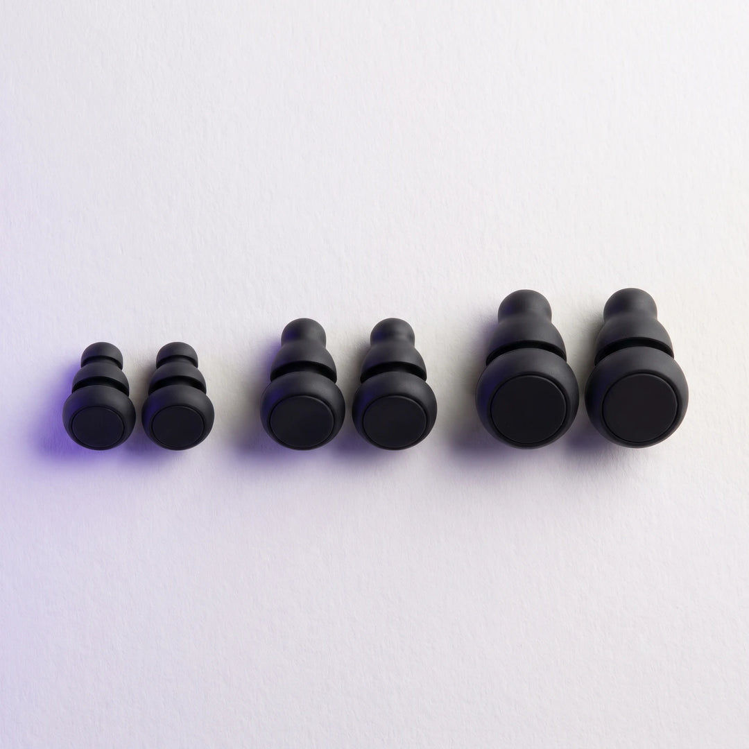 Three pairs of earplugs laid out small, medium and large