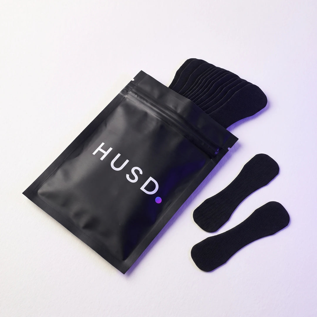 The resealable pouch open, a stack of nasal strips sliding out of it