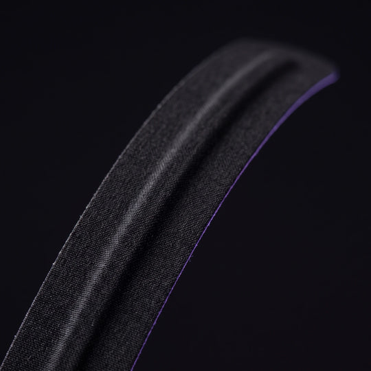 Macro of a single nasal strip showing the woven fabric surface and the spring core